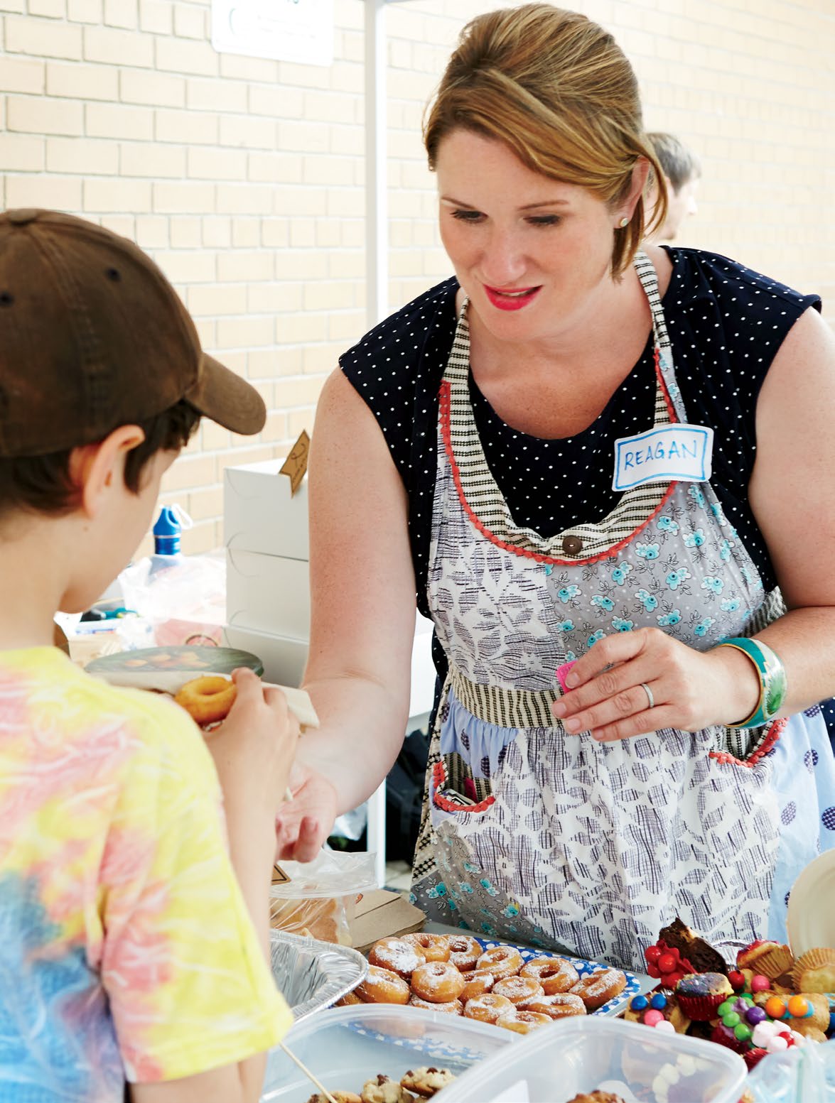 Photo d’une bénévole offrant des gâteries à un élève à l’occasion d’une cueillette de fonds.
