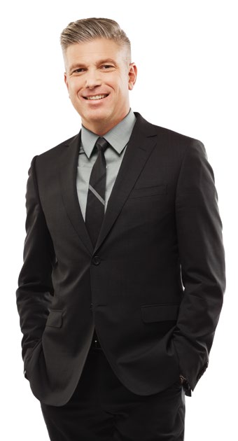 Photo de Michael Salvatori, chef de la direction et registraire. Il est debout, les mains dans les poches, et sourit.