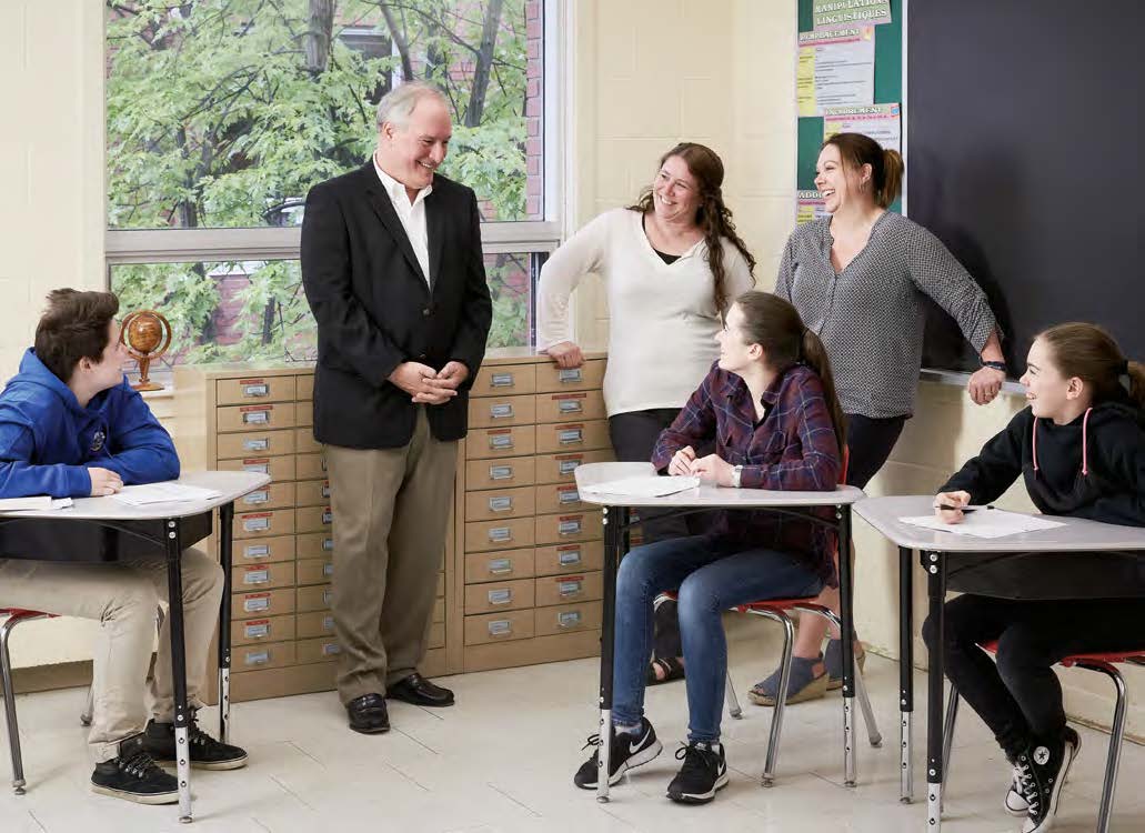 Pierre Riopel, enseignant agréé de l'Ontario, entouré de trois élèves, d'une conseillère en orientation et de la directrice de l'école