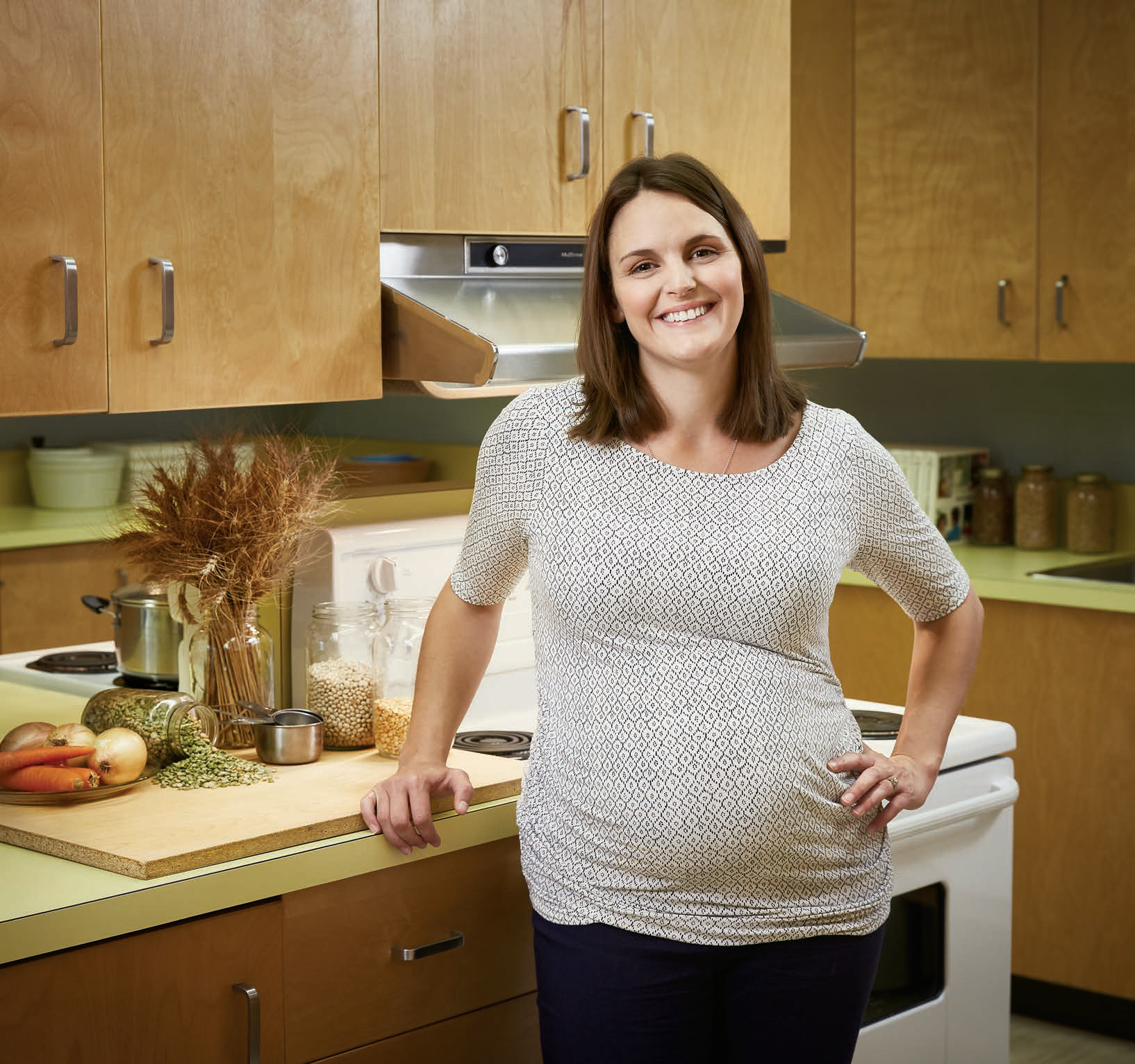 Photo d'Isabelle Montigny, enseignante agréée de l'Ontario, debout devant un comptoir et une cuisinière dans un atelier de cuisine.