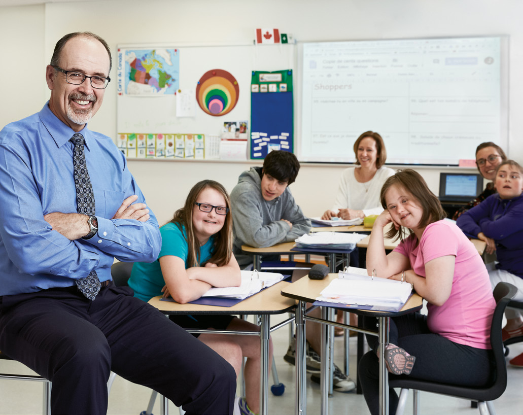Photo de Sylvain Plourde, EAO, avec, à l'arrière-plan, quelques élèves et une enseignante dans une classe.