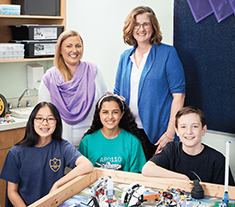 Photo de Shauna Nelson et de Sari McDowell, enseignantes agréées de l’Ontario, debout derrière trois élèves dans une classe de robotique. Plusieurs robots faits à partir de pièces LEGO se trouvent devant eux.
