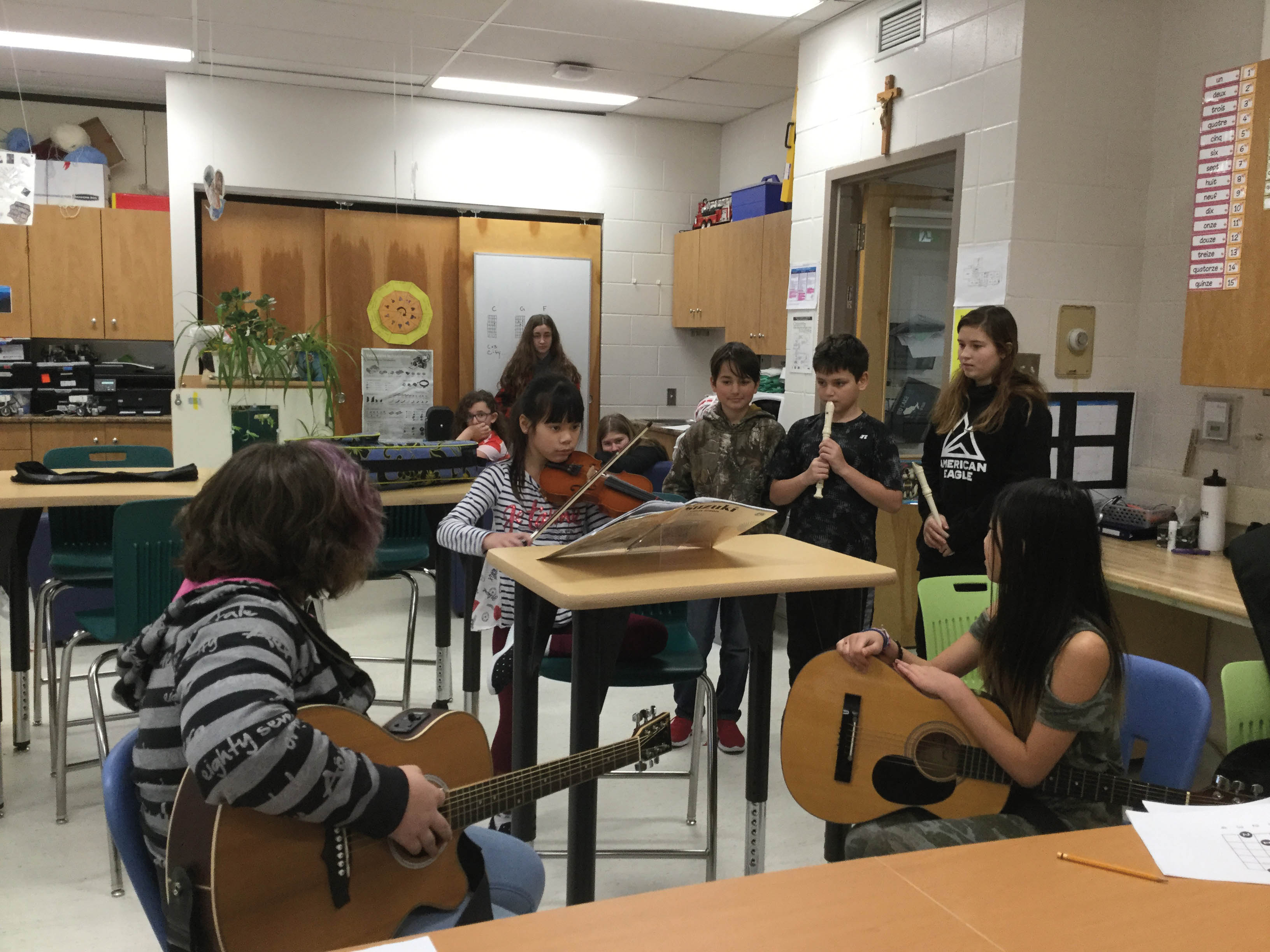 Des élèves jouant divers instruments de musique dans une salle de classe