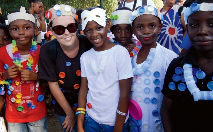 Photo d’Andréanne Grenon-Savard, enseignante agréée de l’Ontario, avec des élèves de la Guadeloupe. Ils portent des masques, des bandeaux et des colliers qu’ils ont fabriqués eux-mêmes.