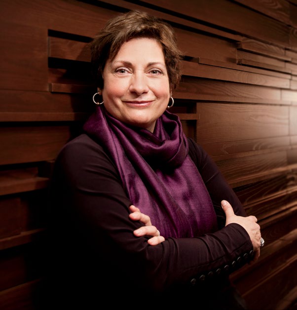 Photo de Lise Paiement, enseignante agréée de l’Ontario, appuyée contre un mur de bois.