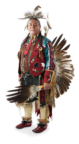 Photo d’un grand chef autochtone portant un habit traditionnel orné de broderies et de plumes.