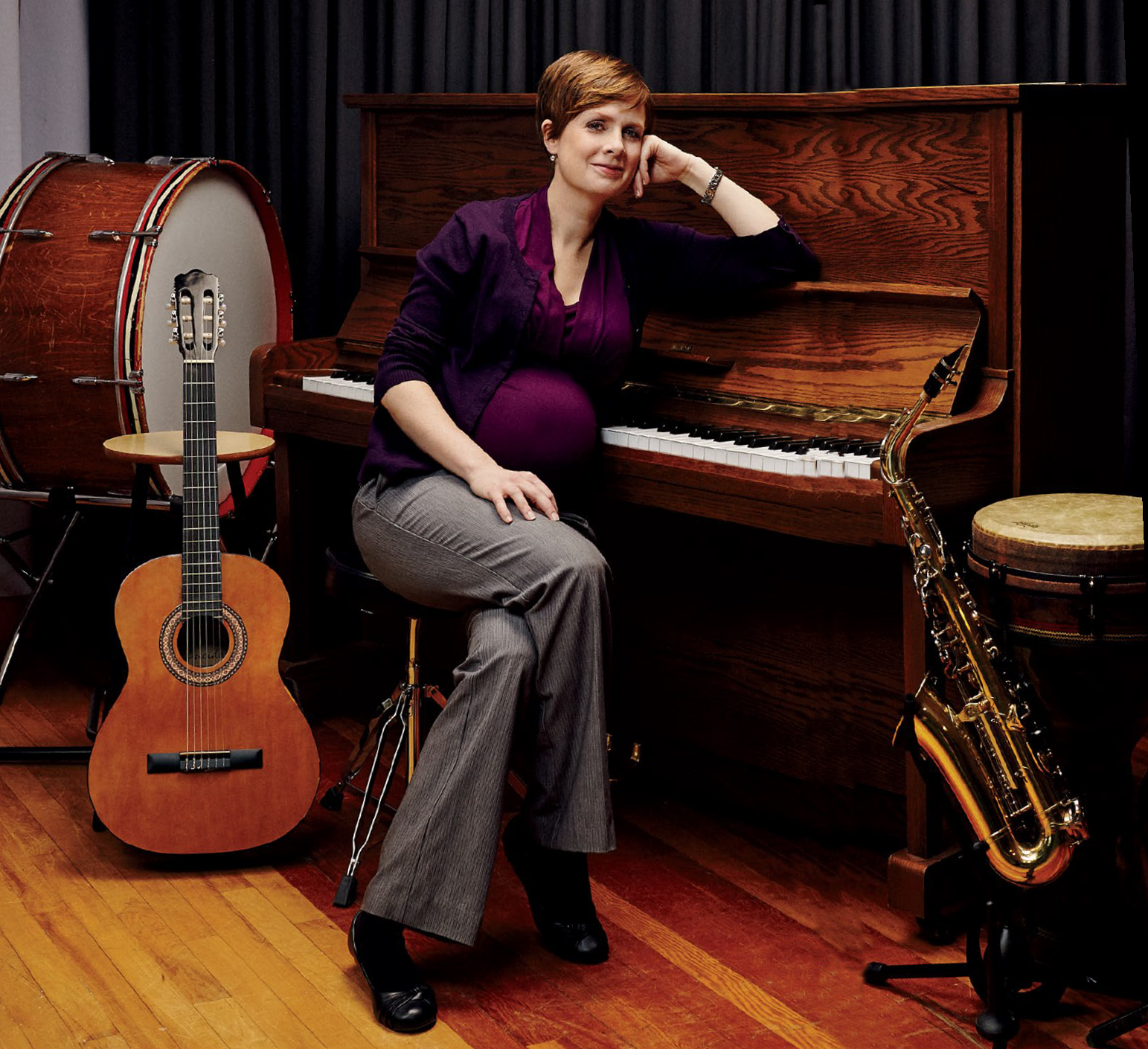 Photo de Dominique Lorraine, enseignante agréée de l’Ontario, assise à un piano, entourée d’instruments de musique.