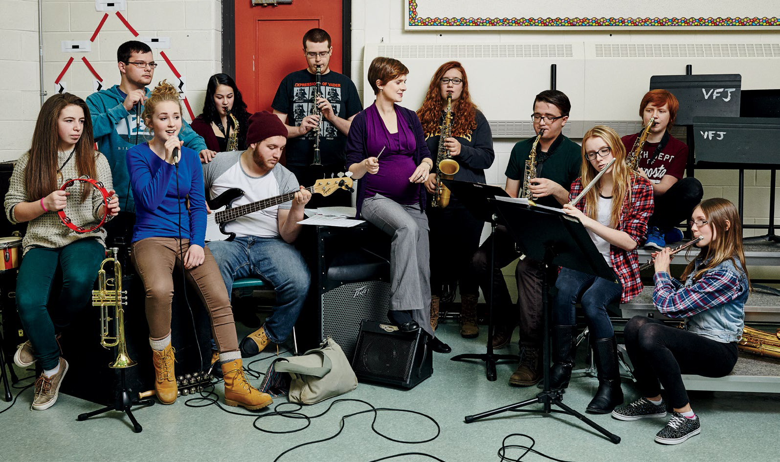 Photo de Dominique Lorraine avec ses élèves dans la classe de musique lors d’une répétition de l’orchestre de l’école.