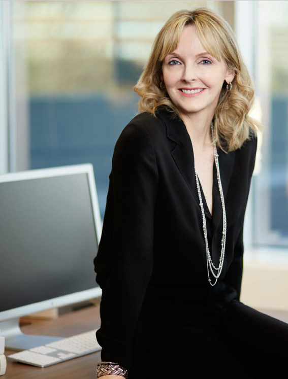 Photo de Kirstine Stewart assise sur un bureau.