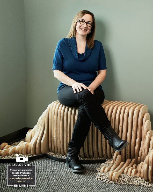 Photo de Martine Comeau, enseignante agréée de l’Ontario, assise sur une création artistique en bois.
