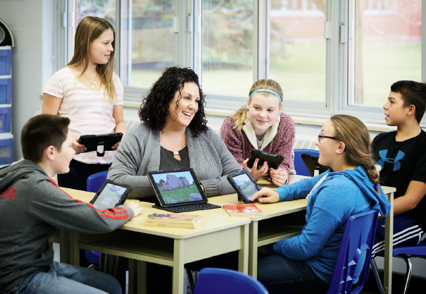 Photo de Joey Jackson, enseignante agréée de l’Ontario, assise avec des élèves. Tous les élèves utilisent des tablettes.
