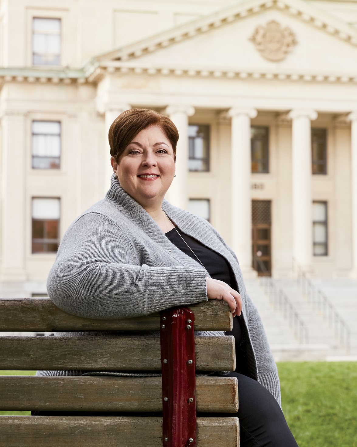 Photo de Sylvie Lamoureux, enseignante agréée de l’Ontario, assise sur un banc devant un édifice de l’Université d’Ottawa.