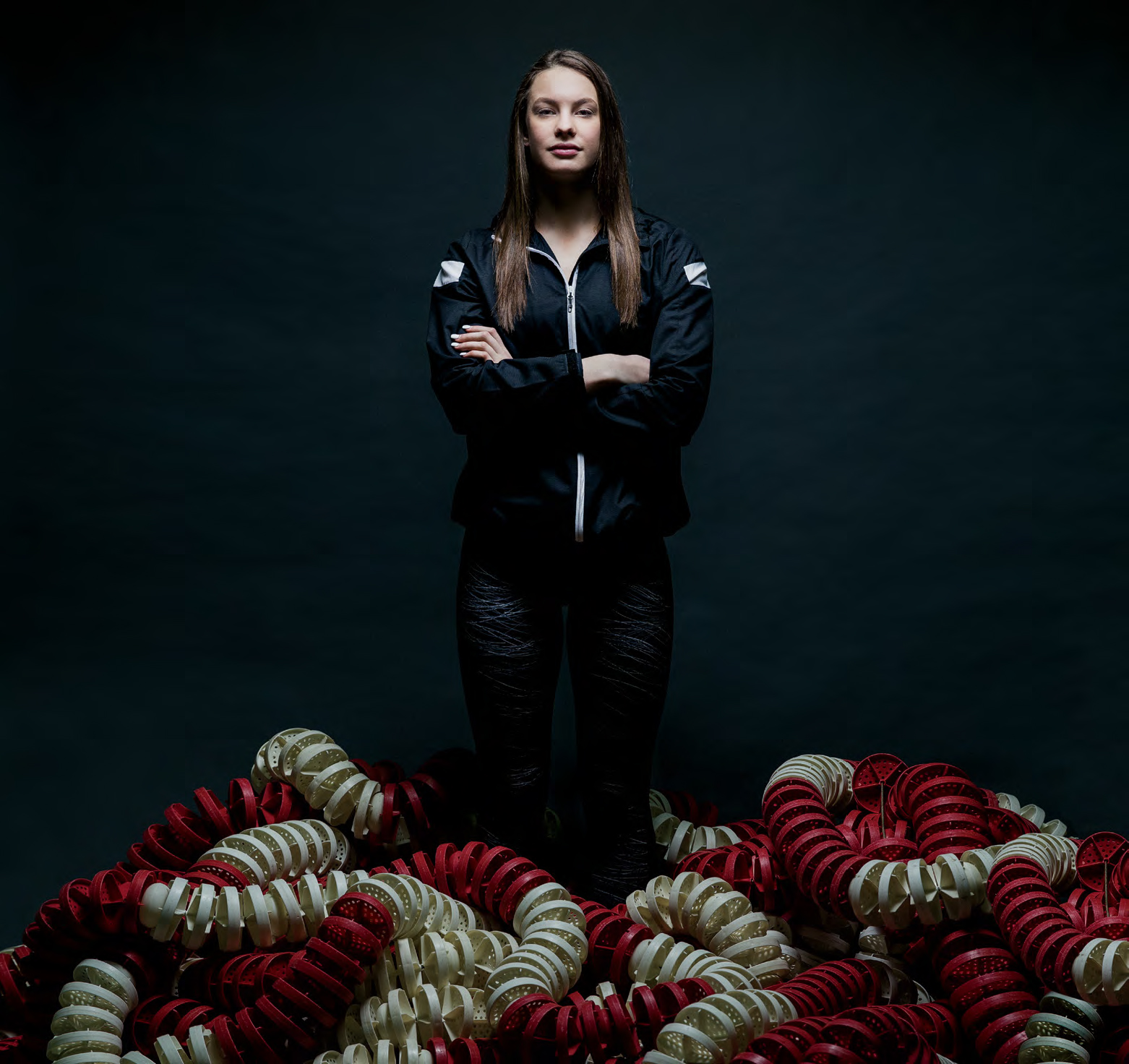 Photo de la nageuse olympique Penny Oleksiak, debout avec les bras croisés, aborant un air de confiance.