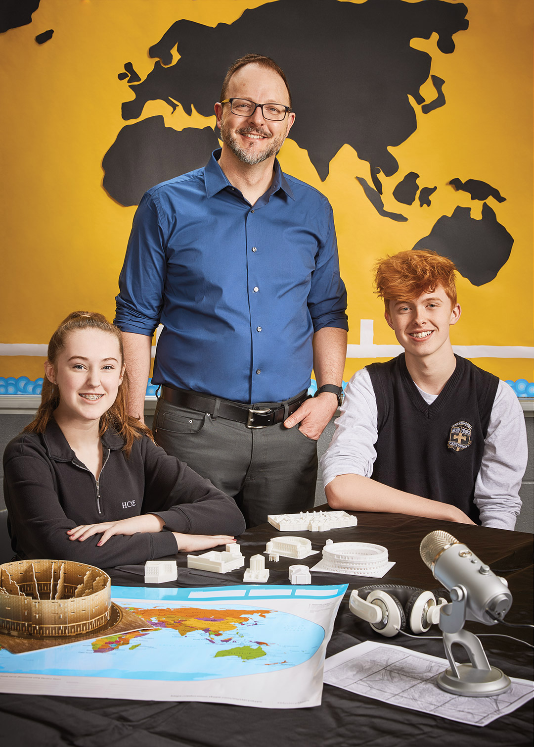Photo de James Pedrech, enseignant agréé de l’Ontario, debout derrière deux élèves assis à une table.