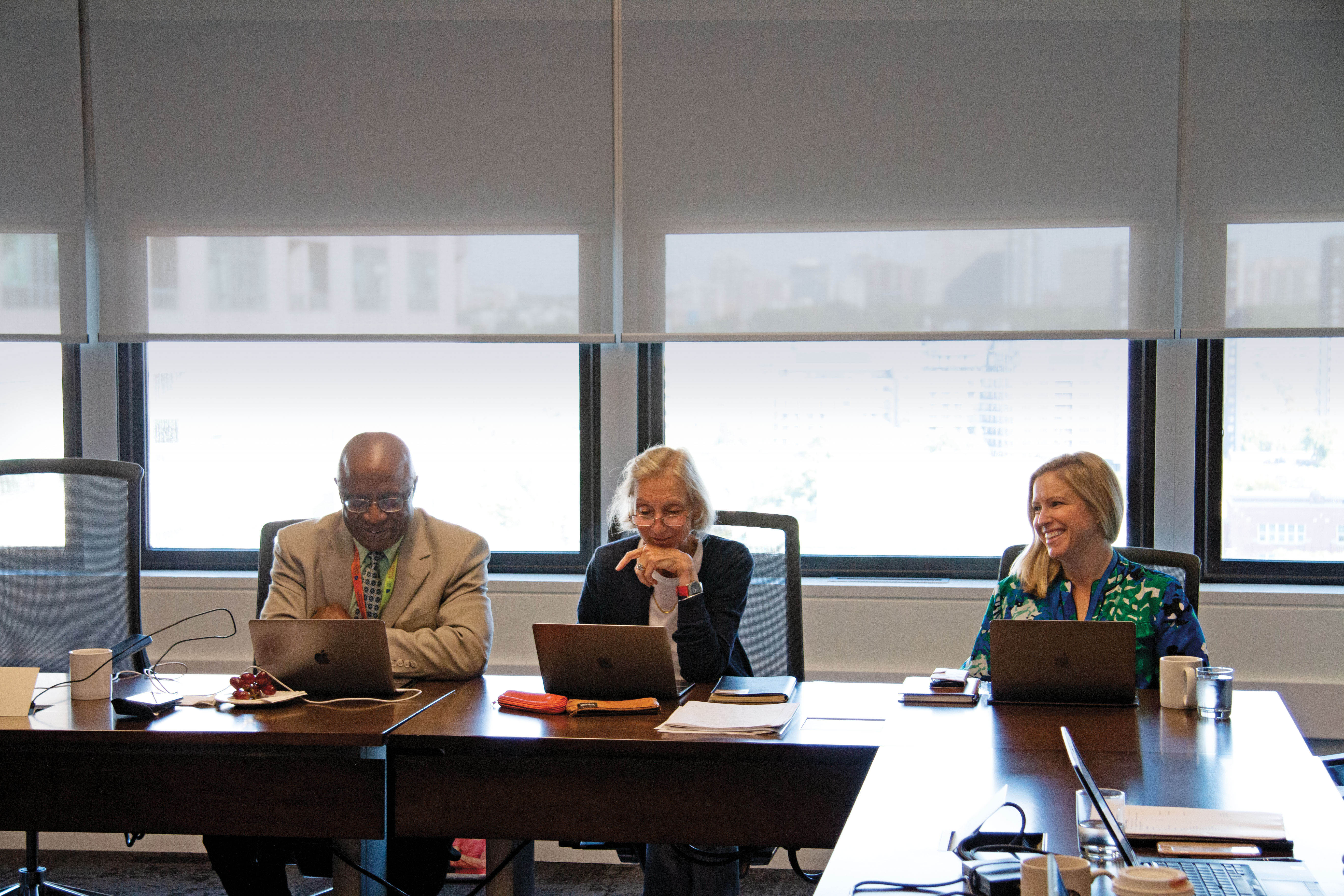 Photo de membres du comité de rédaction de l’Ordre examinant le contenu du numéro de décembre de 'Pour parler profession' et de 'Professionally Speaking'.
