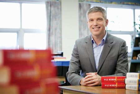 "Photo of College Registrar Michael Salvatori seated at a desk.