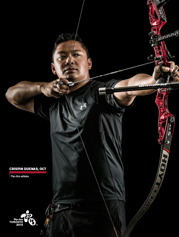 Photo of Crispin Duenas, Ontario Certified Teacher, standing with a recurve bow.