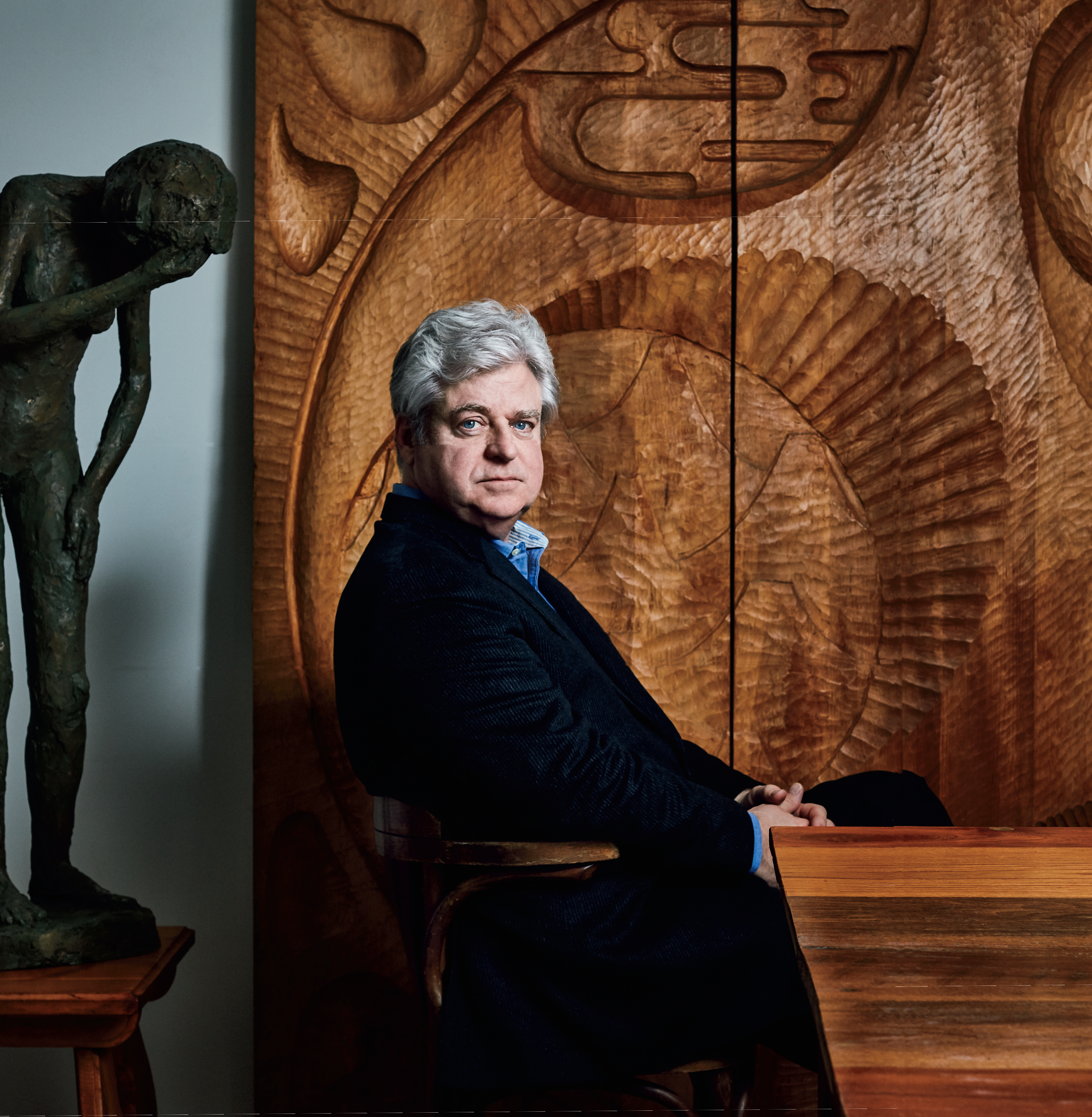 Photo of Crime writer Linwood Barclay seated at a desk. Linwood's body is parallel to the camera with his head looking over at the camera.