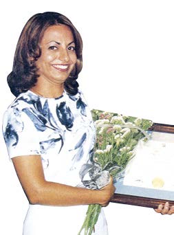 Photo of Luci Loisi, Ontario’s first certified teacher, holding flowers and certification.