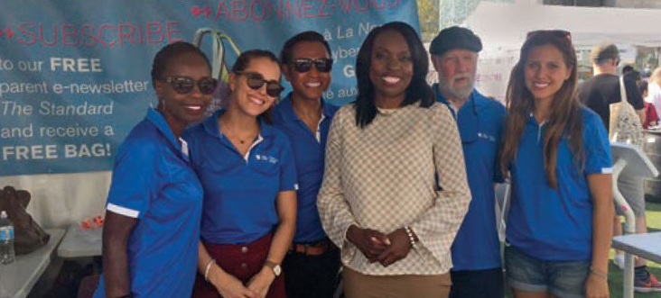 Photo of Mitzie Hunter, Ontario Education Minister, standing with staff from the Ontario College of Teachers during "The Word on the Street" in Toronto.