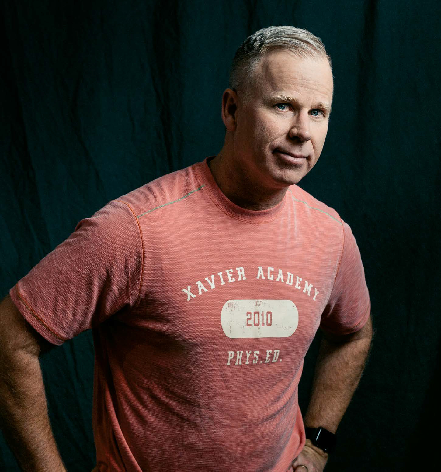 Gerry Dee standing with hands behind his back.