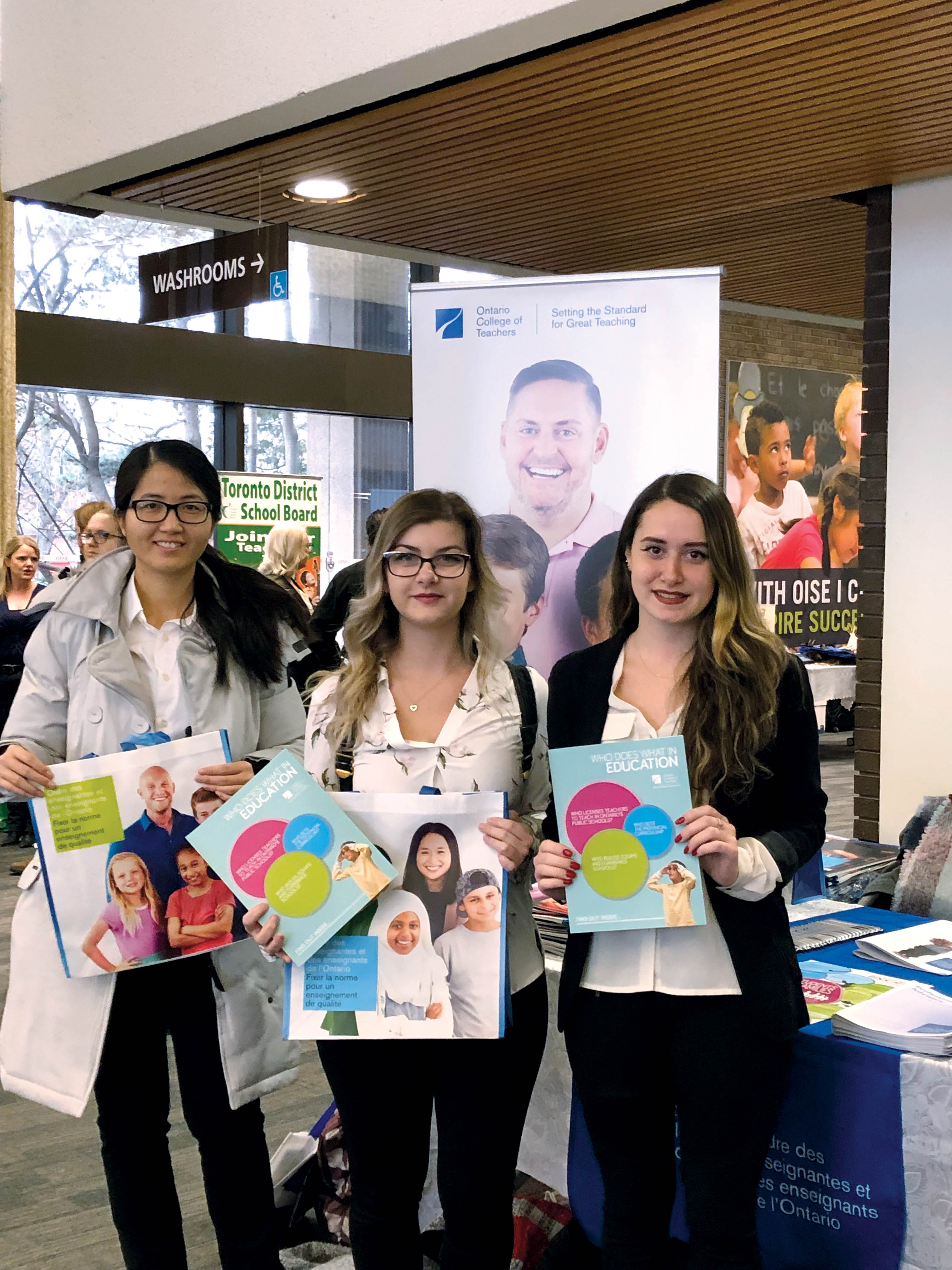 Photo of three people holding College materials.