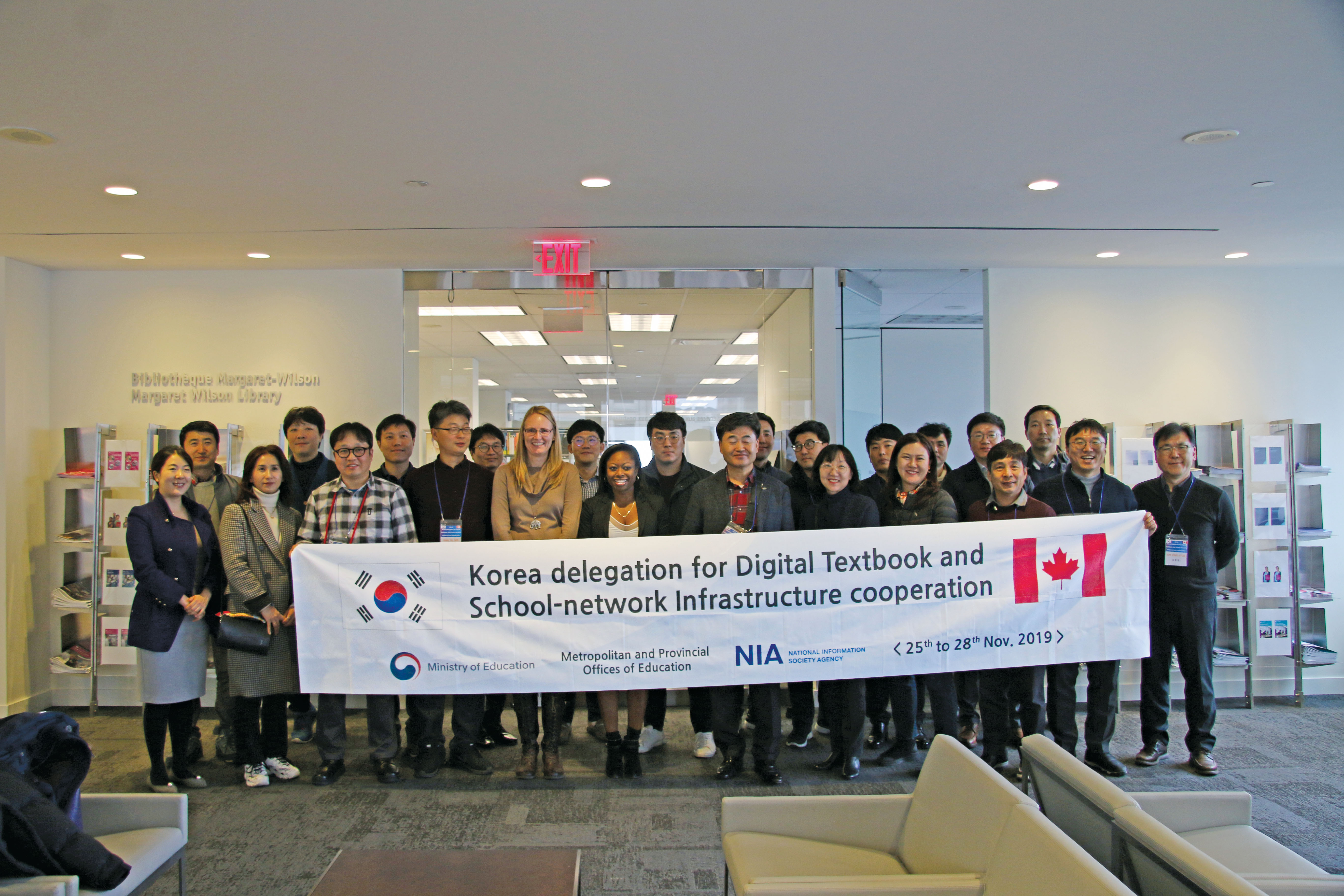 Photo of a South Korean delegation smiling and holding a banner.