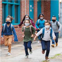 Five students of various ethnicities running outside.
